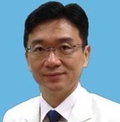 an image of Hsu wearing a white shirt, black tie and smiling 