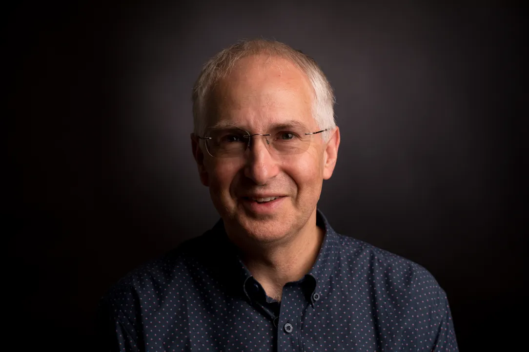 Portrait photo of Professor Ian Gilbert with dark background