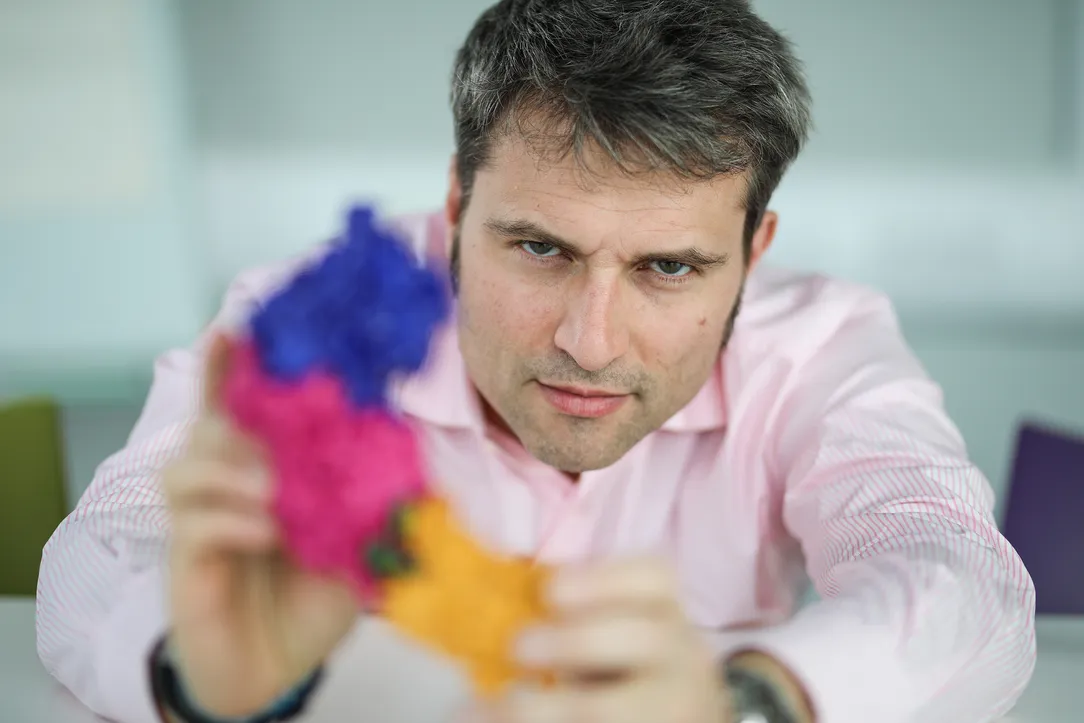 Professor Alessio Ciulli holding a blurry model