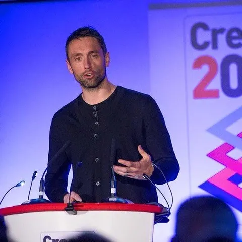 a man standing at a podium giving a talk