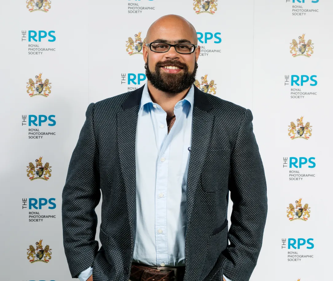 Tobias smiling with his hands in his pockets