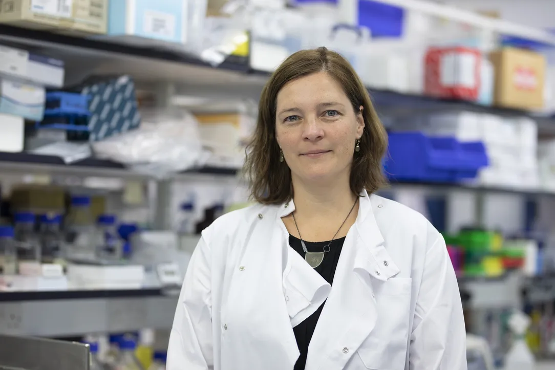 Dr Esther Sammler with shelves full of equipment behind her 