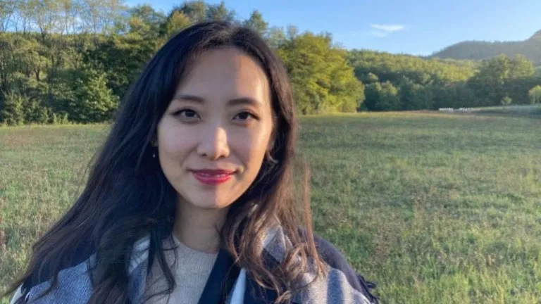 Ulrim Yang stands in a field looking towards the camera.