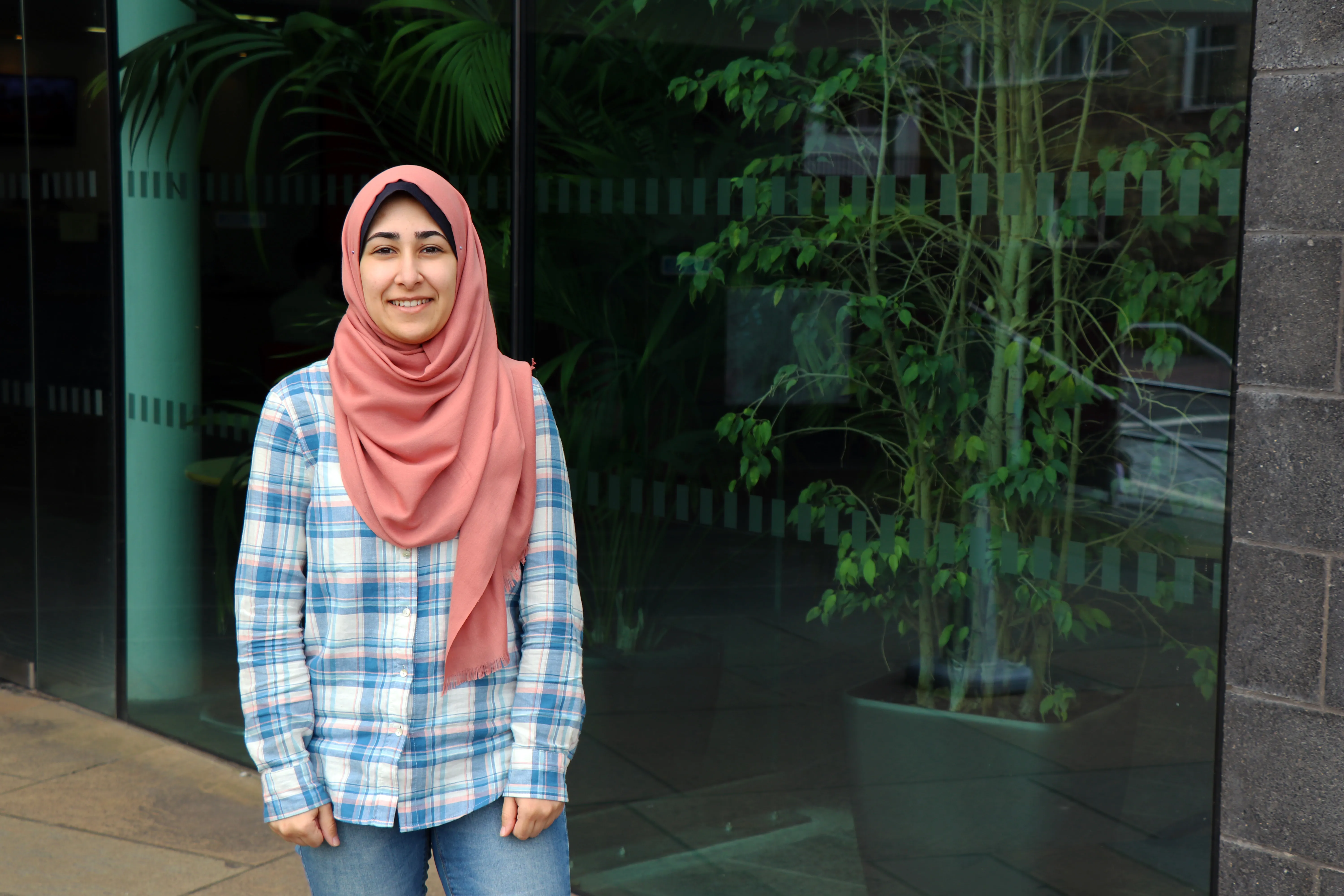 a student standing outside with plants