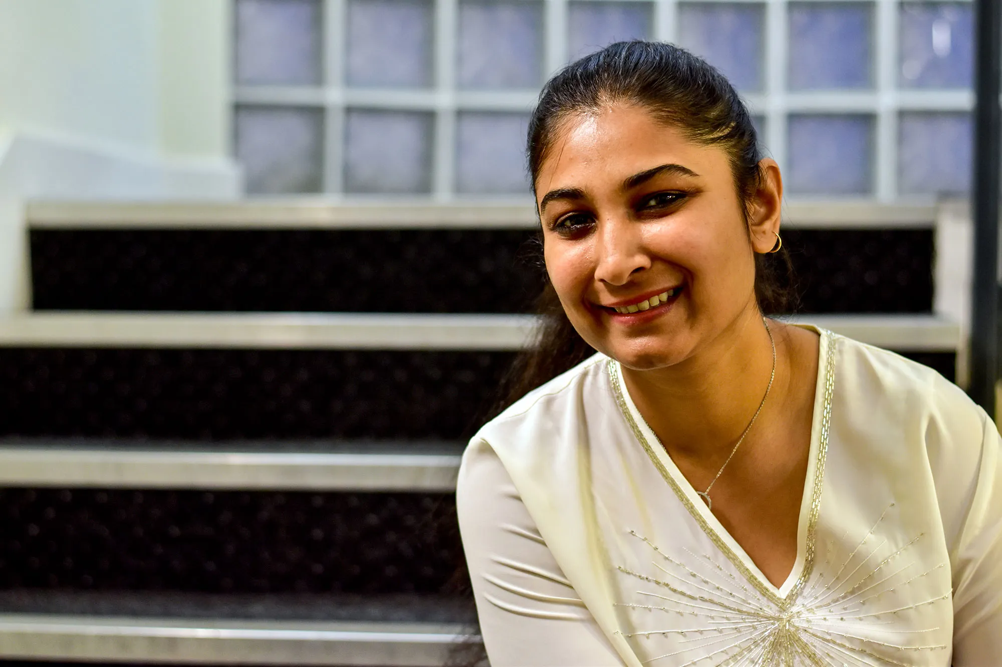Photo of a graduate Anchal Chaurasia sitting on some stairs
