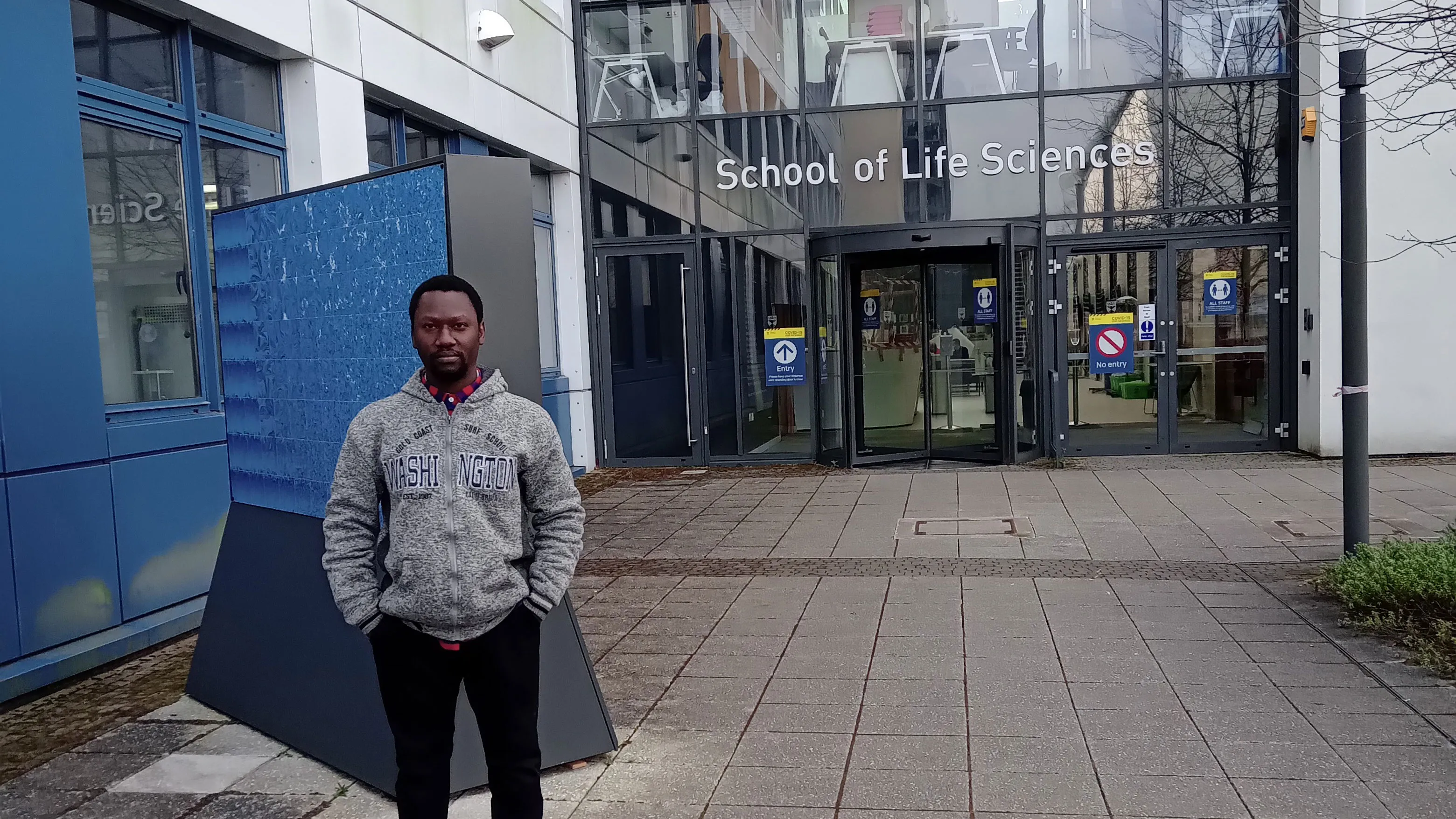 Victor Ayo Adediwura stands in front of the School of Life Sciences entrance.