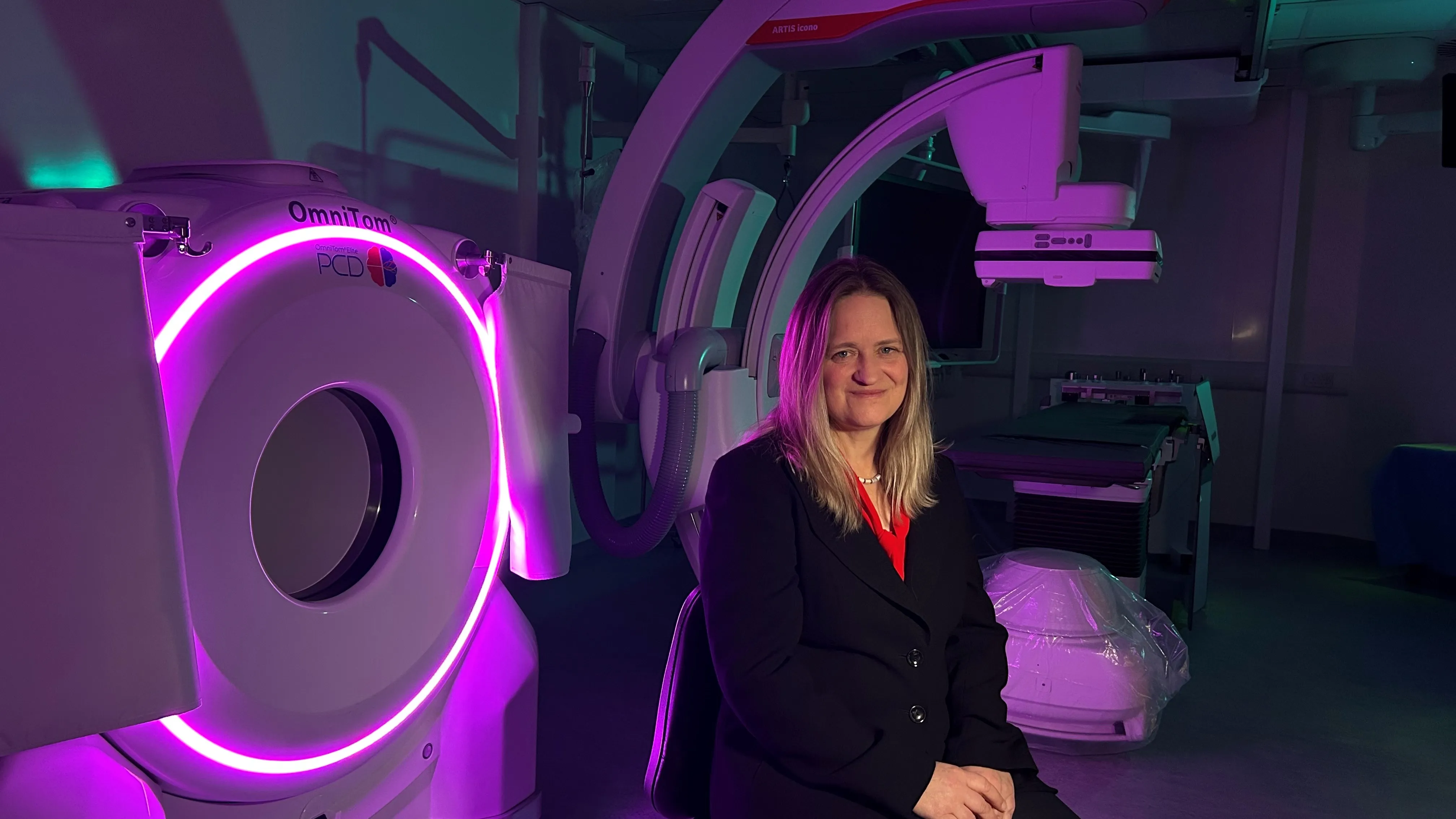 Woman standing in front of medical machines with purple light