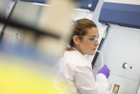Staff in white coats in a lab