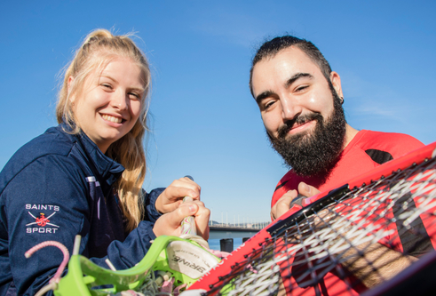 Grinning students from the Universities of Dundee and St Andrews brandish racquets at the camera