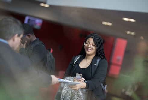 a student being handed a leaflet