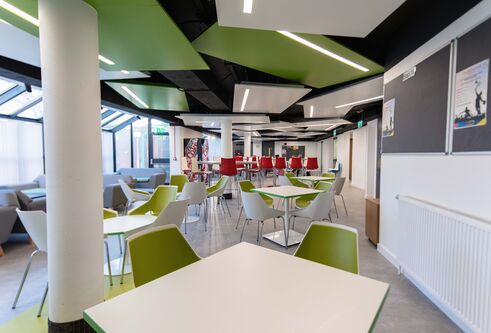Green and red tables and chairs in dining room