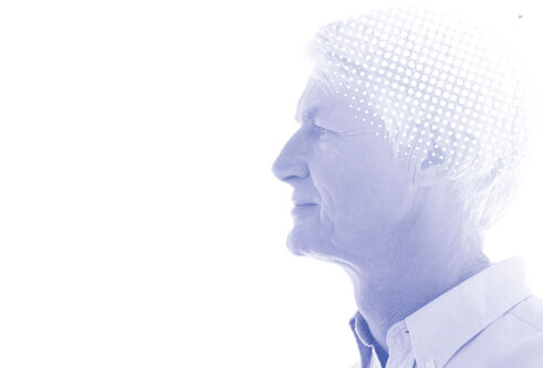 A white haired man staring to the left with a blue colour wash over the photo