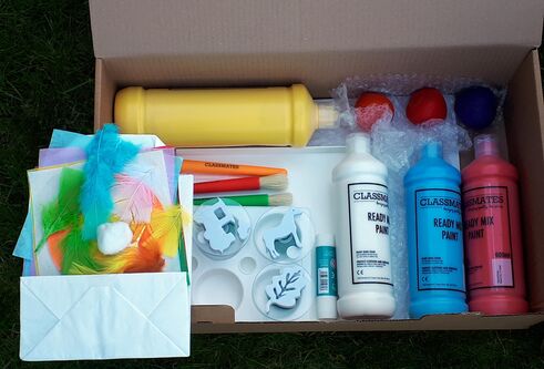 A cardboard box containing bottles of paint