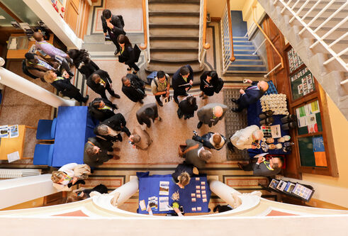 a birdseye view of a group of people at an event in a hallway with stairs