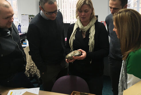 a group of people standing around a table 