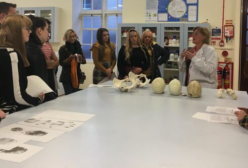 a group of school pupils standing around table getting a lesson in anatomy