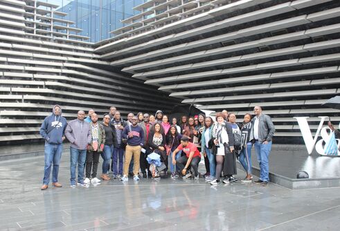 a group of people standing in front of the V&A museum