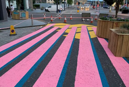 a street that has been painted with pink and blue stripes
