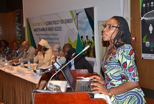 a woman standing at a podium talking 