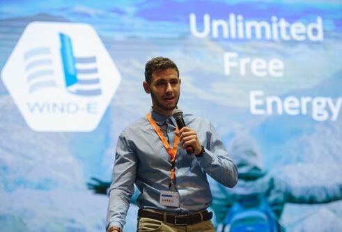 Harris at the competition, bright blue screen with unlimited energy written on it 