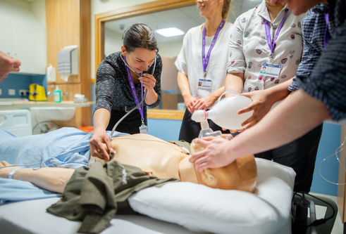 Undergraduate medicine students working with a dummy