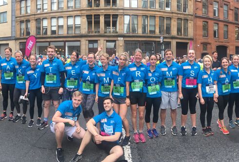 people in blue t-shirts all standing together before a race