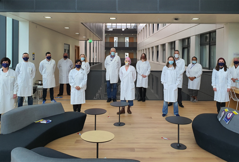 researchers in lab coats and masks