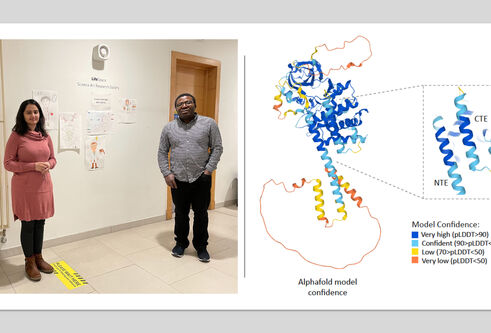 Man and woman standing by poster showing DNA