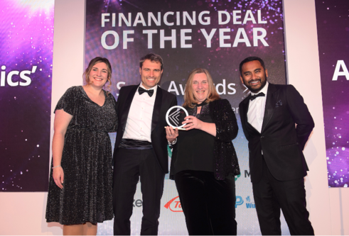 Scrip Awards - four people in evening dress standing in front of banner reading 'financing deal of the year'