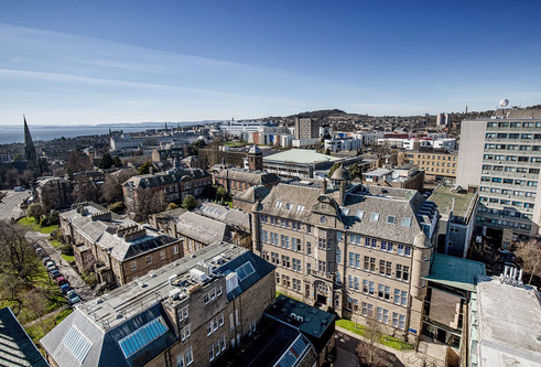 Aerial view of the city campus with blue skies and view of the Old Medical School and Geddes Quadrangle