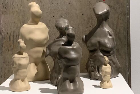 miniature sculptures of a naked woman's body in a mix of light and dark colours