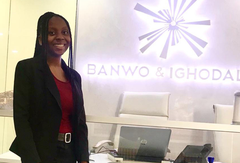 Abimbola Ibiwoye standing in front of an office sign for Banwo & Ighodalo