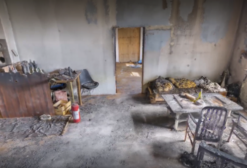 A still image from the digital virtual reality scene showing a burned room