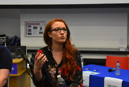 Presenter at the Venture 2018 competition sitting in a conference room giving a speech
