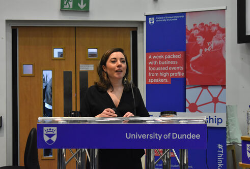 A person standing at a podium for the Venture 2019 finals competition presented by Centre for Entreprenuership