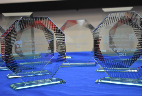 Glass trophies for Venture competition winners sitting on a table with a blue table cloth