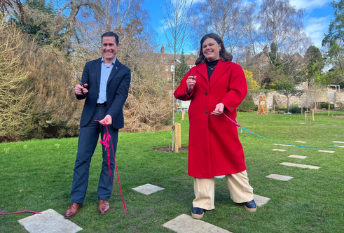 Lorena Weepers, pictured with Dr Jim McGeorge stood in the garden holding ribbon 