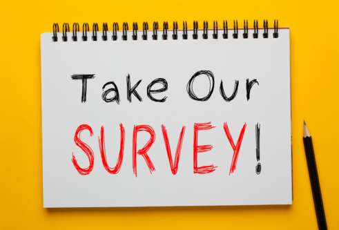 Take our survey written on a note pad