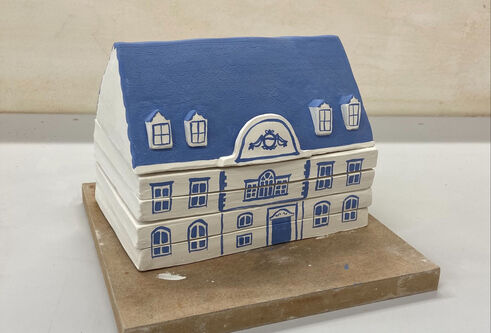 A small model house made of ceramic tiles
