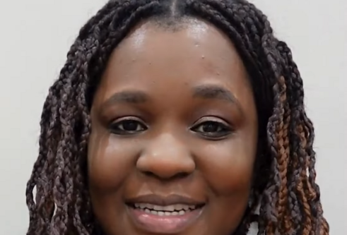 female student in front of grey background