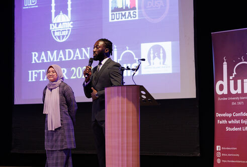 Image of speakers on stage at the iftar event