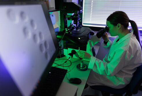 A person looking through a microscope