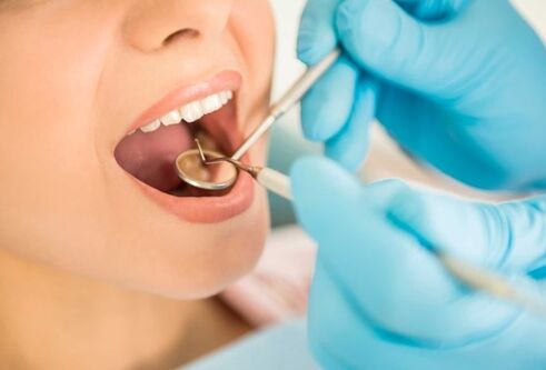 A person with their mouth open getting a dental check up 