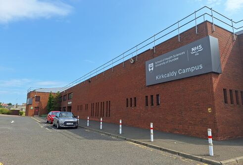 New signage at the entrance to Kirkcaldy campus. The new signage has a grey background with writing on it, and is located above the covered walkway to the building