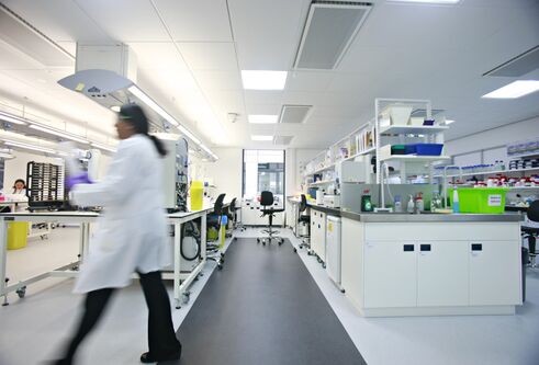 inside a science lab, blurred image of person walking across 