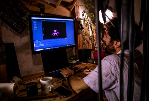 Man in white short sleeved shirt on a desktop computer