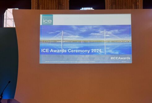 close up on a brown stage backdrop with a landscape poster on it stating ICE Awards 2024