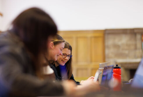 Two students looking at a laptop screen