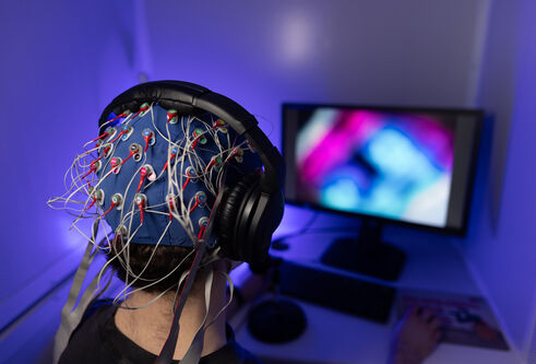 Psychology student sitting with Electroencephalogram EEG headset on