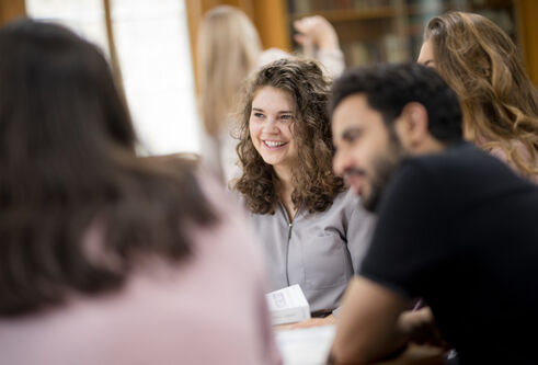 Students sitting smiling and chatting with one another